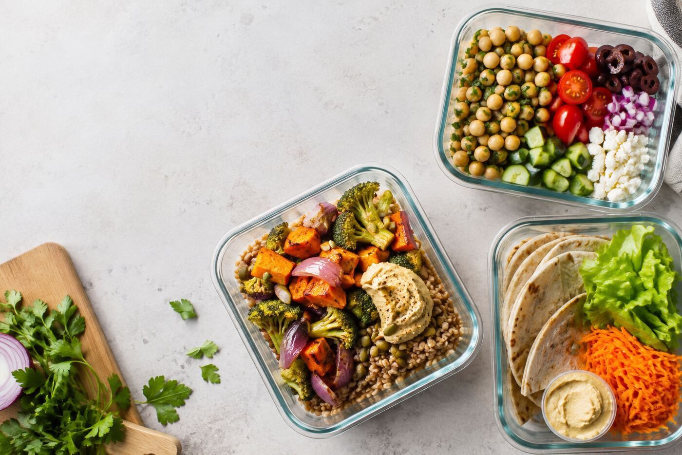 Colourful lunch meal prep containers with chickpeas, roasted vegetables and wraps